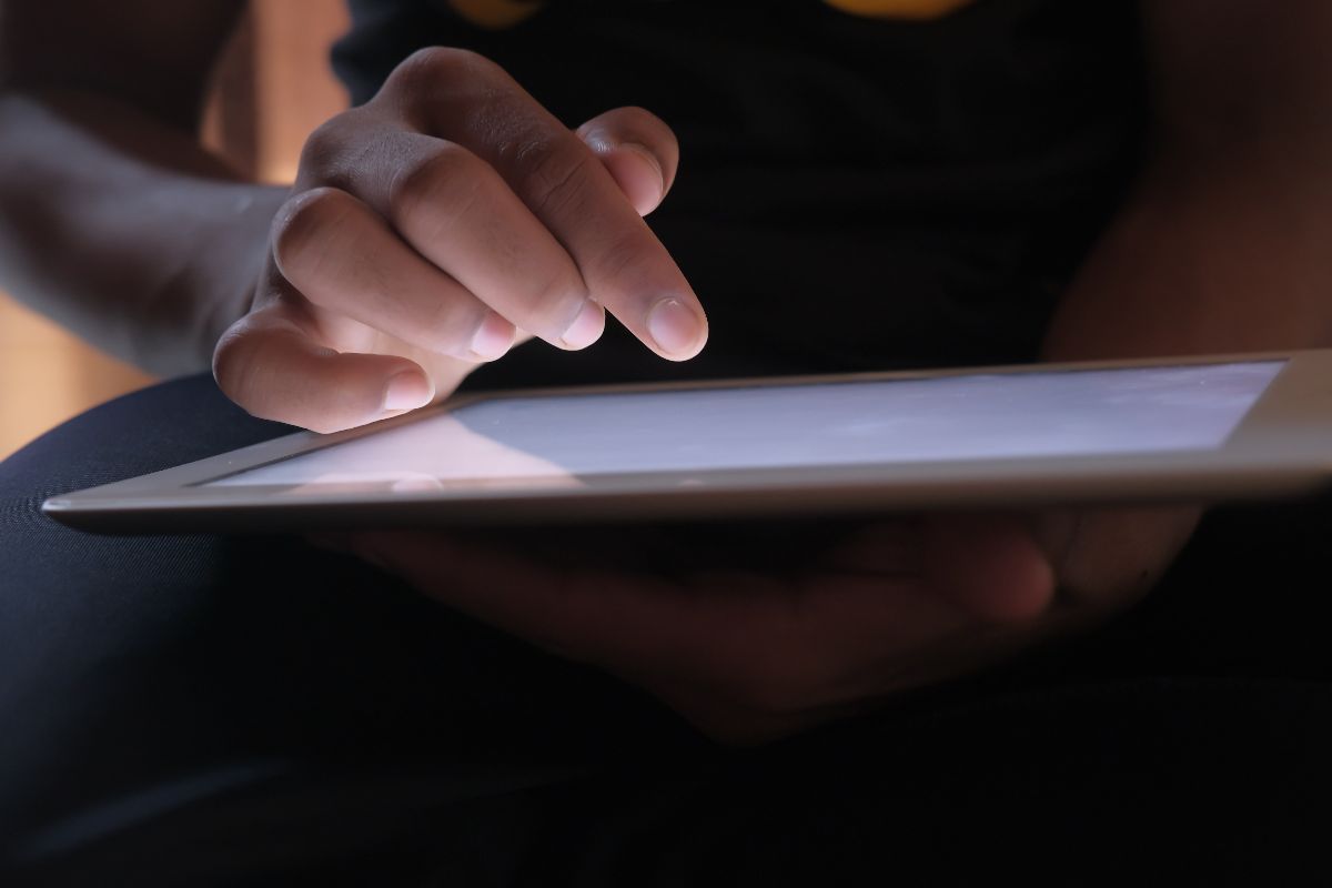 Close-up of a person using a tablet for online research, social media management, and digital marketing.